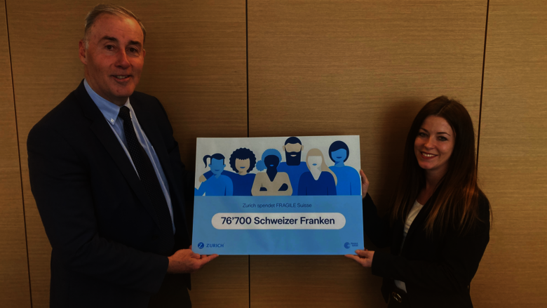 Sandro Meyer übergibt einen Check in Höhe von CHF 76'700.