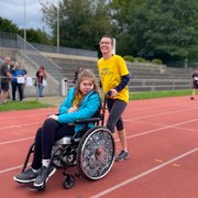 Eine Teilnehmerin im Rollstuhl wird von einer weiteren Läuferin gestossen.